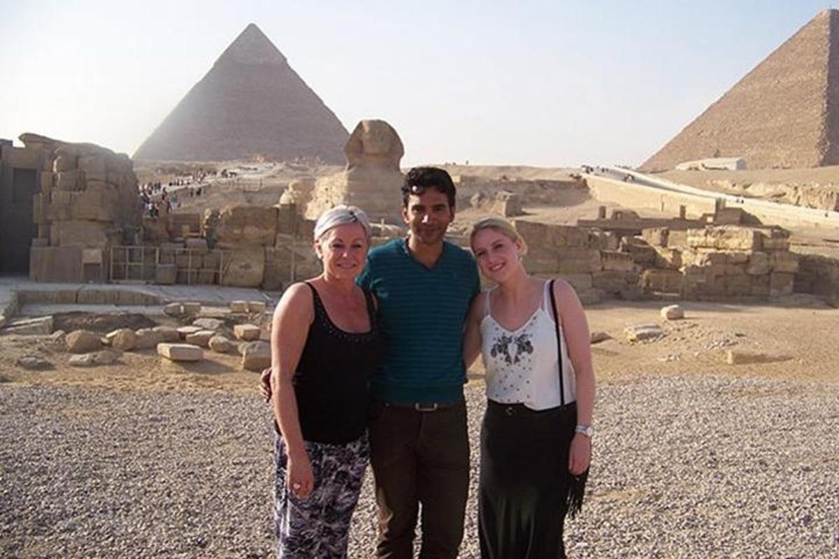 muž a dvě ženy stojící před pyramidami
