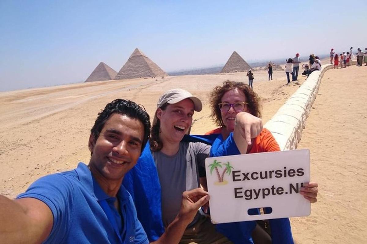 tři lidé držící ceduli u pyramid