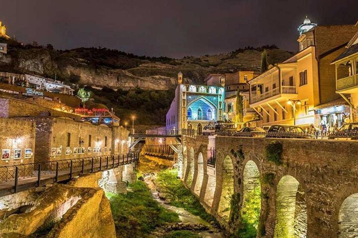 eine Stadt mit einer Brücke über einen Fluss bei Nacht