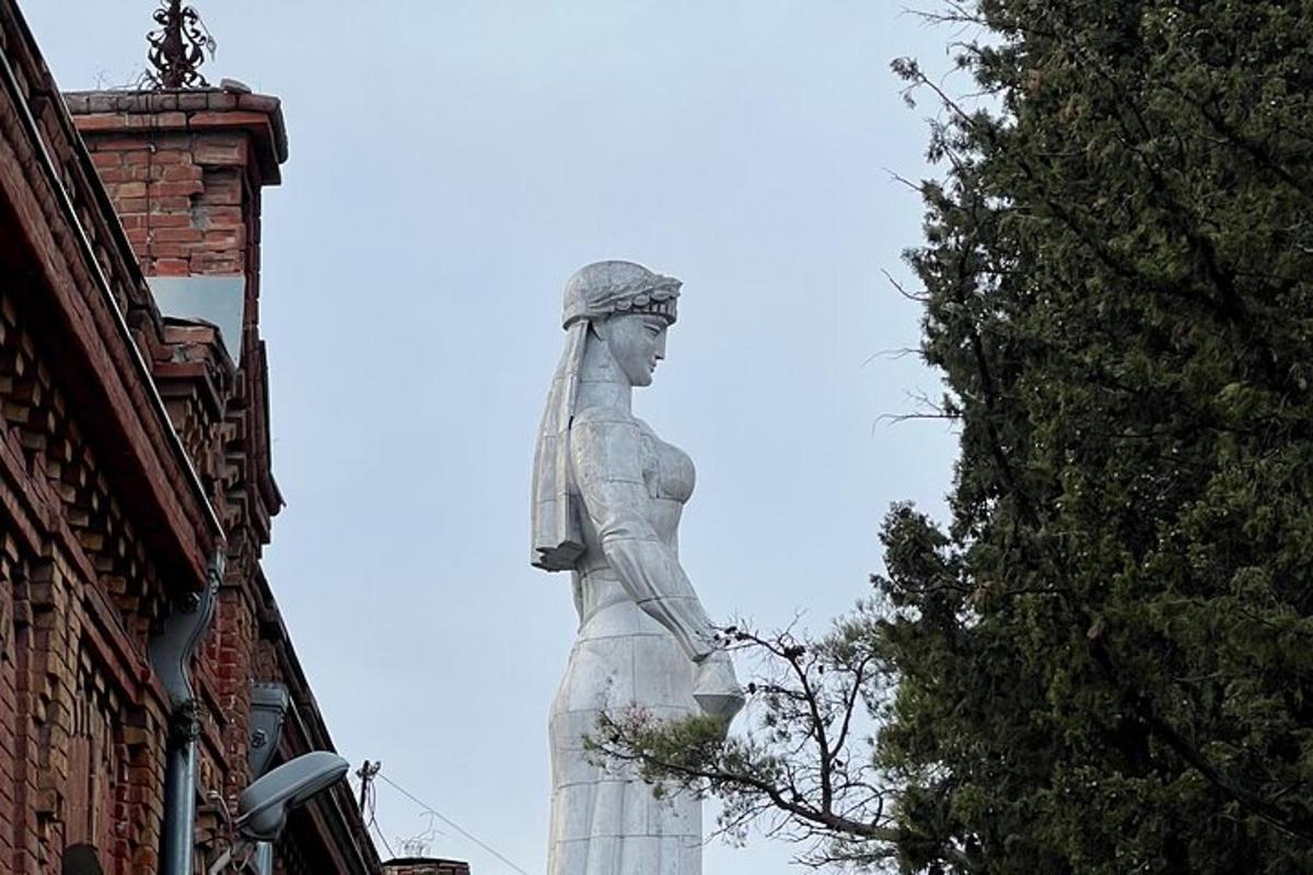 eine Statue einer Frau, die neben einem Gebäude steht