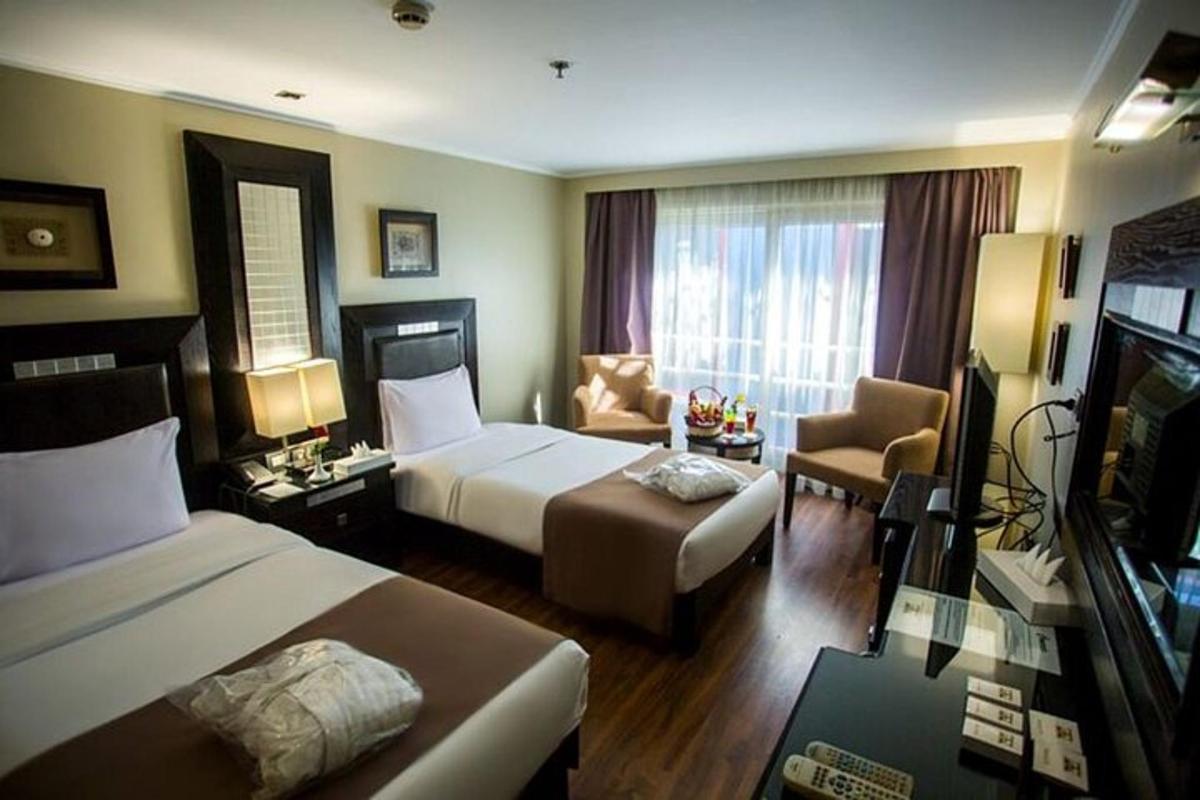 una habitació d'hotel amb dos llits i un sofà