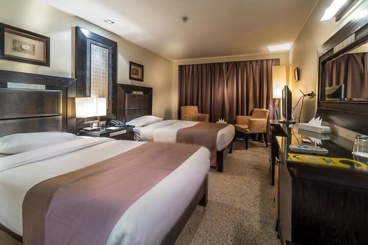 una habitació d'hotel amb dos llits i un televisor