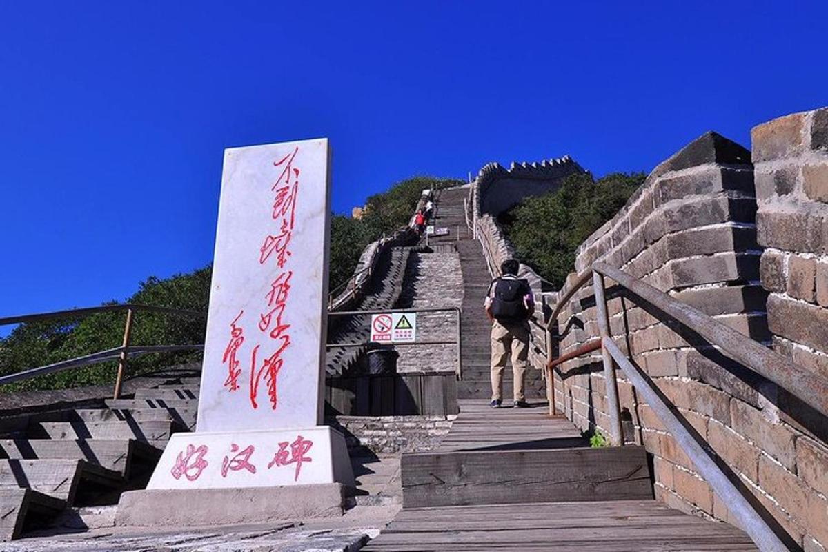 a man walking up the stairs of the great wall