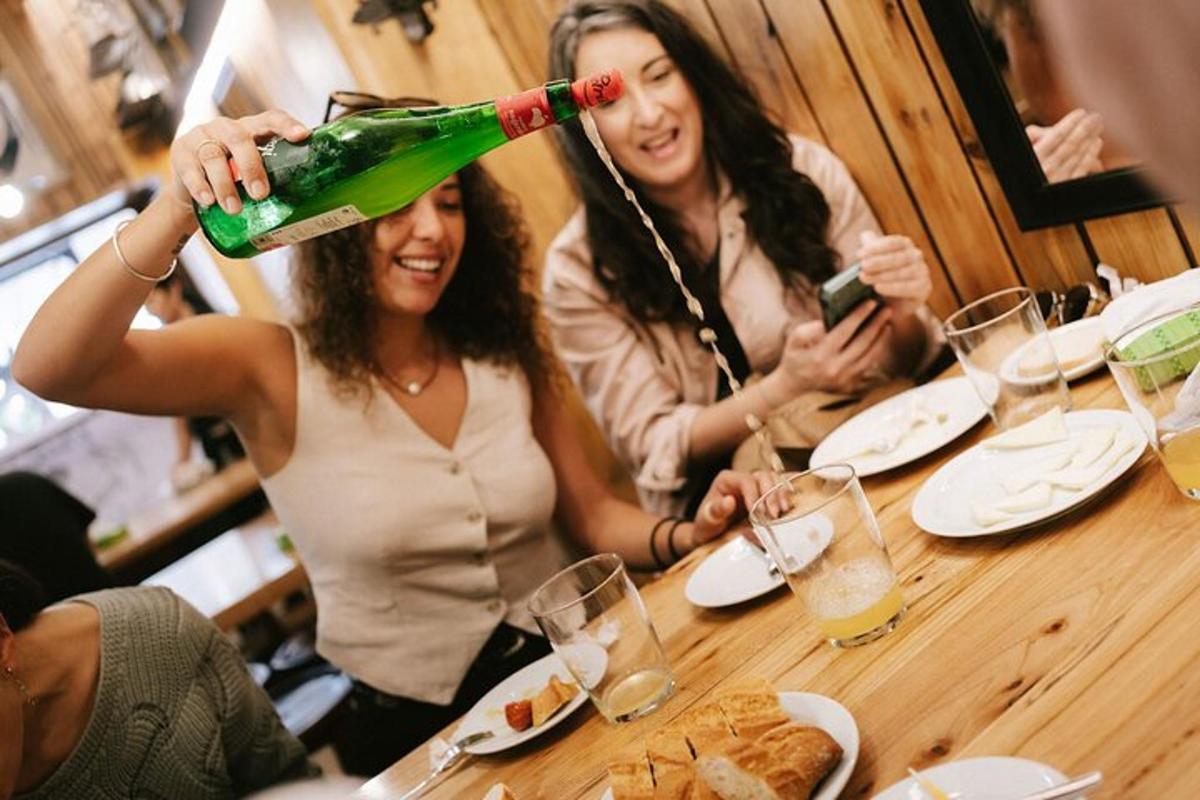 two women sitting at a table with a bottle on their head