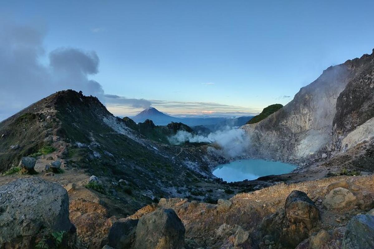 a view of a mountain with smoke and two lakes