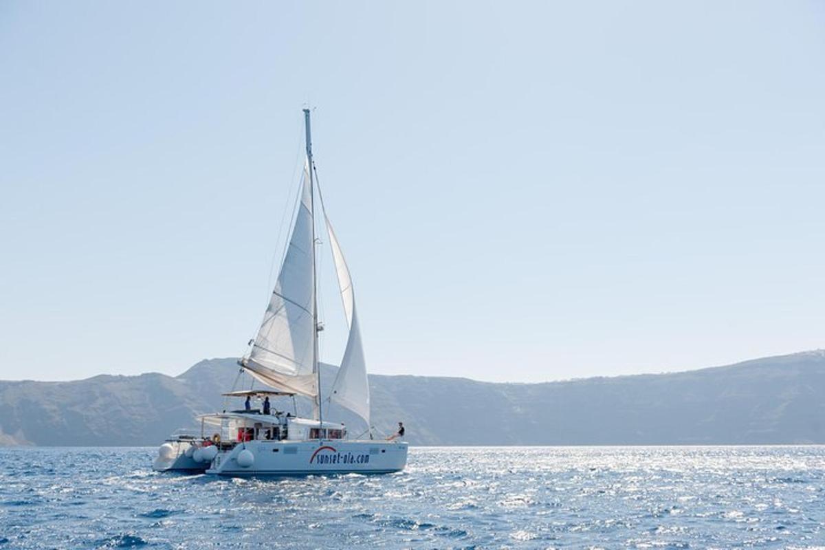 μια βάρκα με ένα άσπρο πανί στο νερό