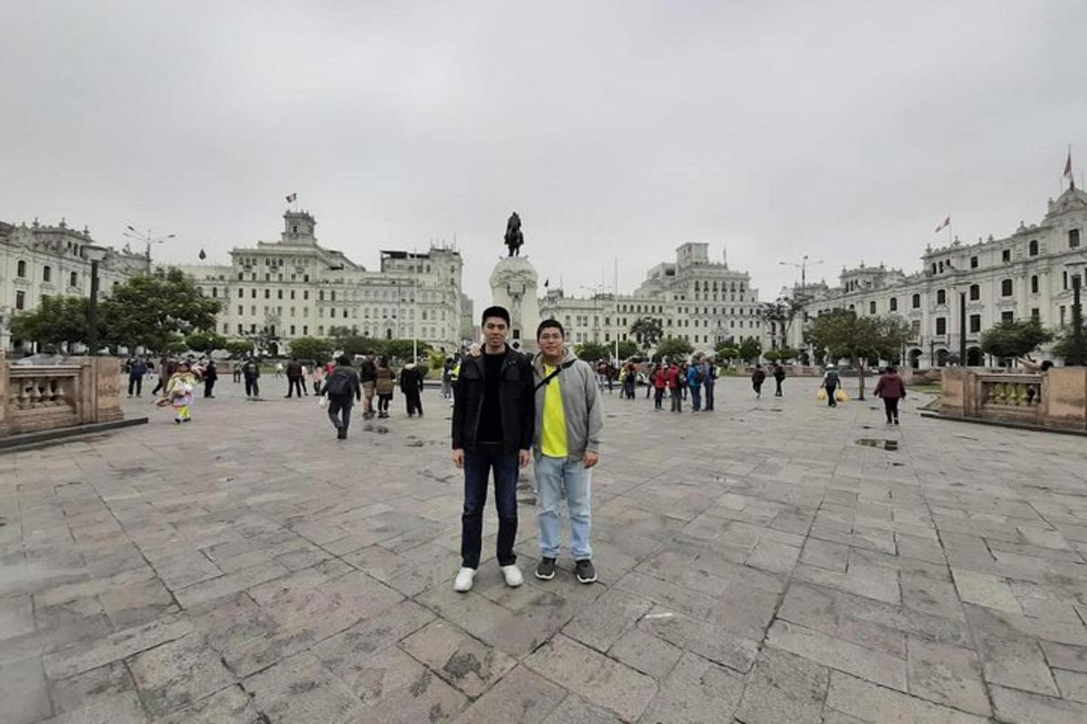 dua lelaki berdiri di dataran di hadapan sebuah bangunan