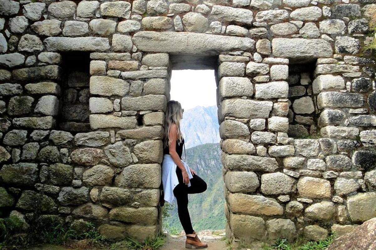 uma mulher parada na porta de uma parede de pedra