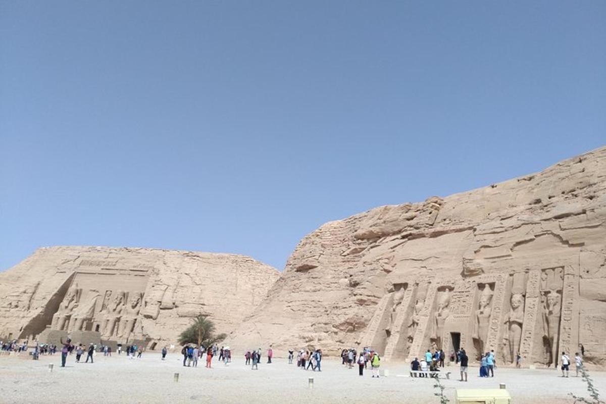 a group of people walking around the side of a cliff