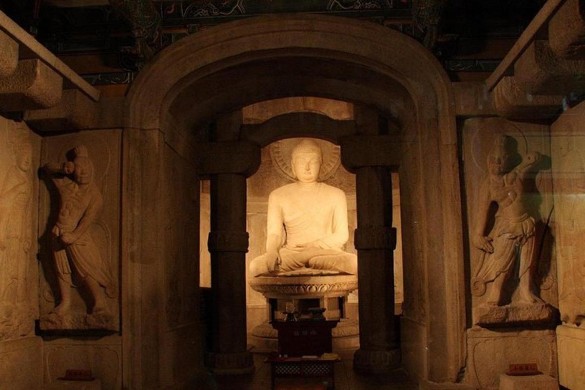 a statue in a room with statues on the wall