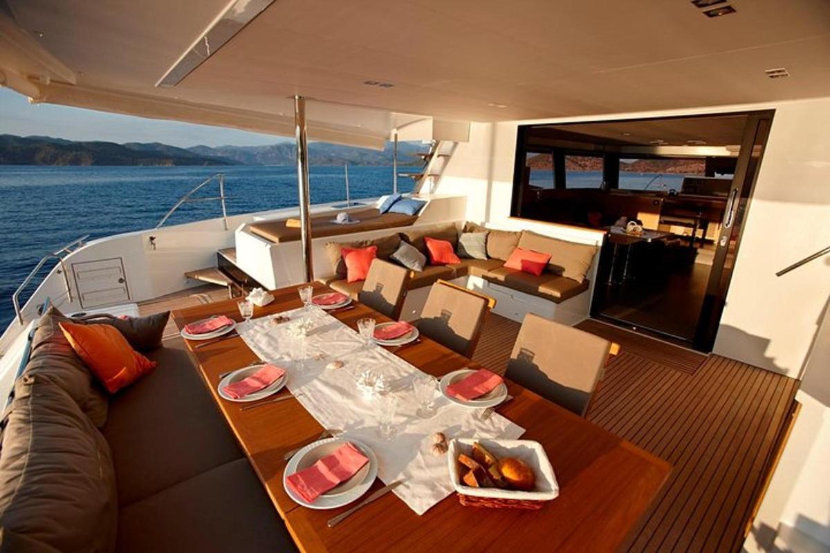 Una mesa y sillas en un barco con una comida encima.