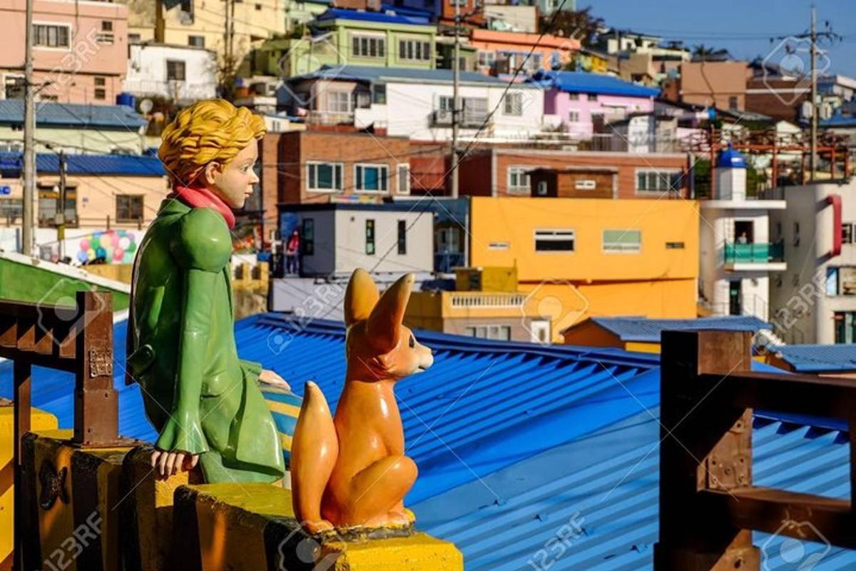 a statue of a girl and a fox on a roof
