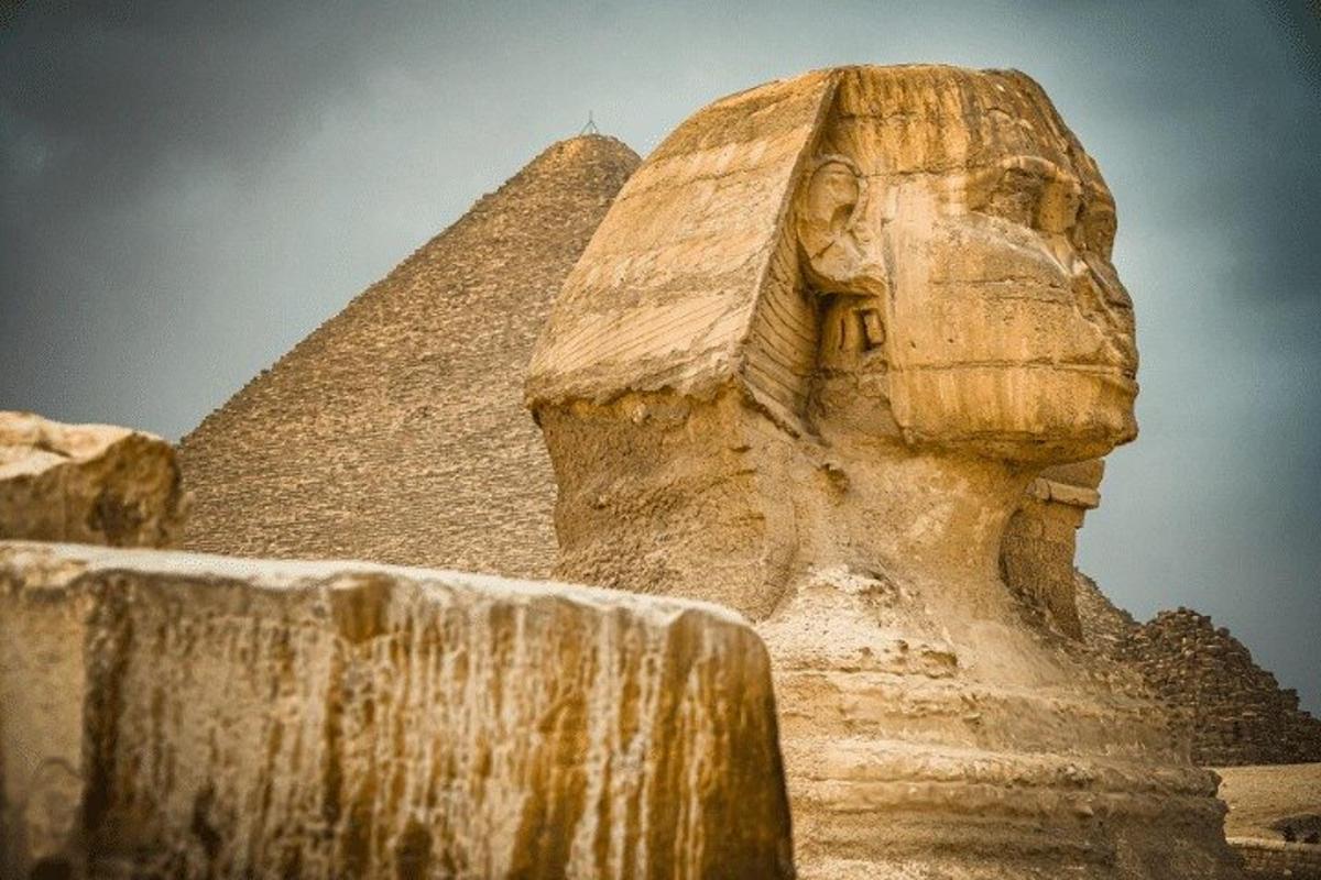 een standbeeld van een hoofd naast de piramide