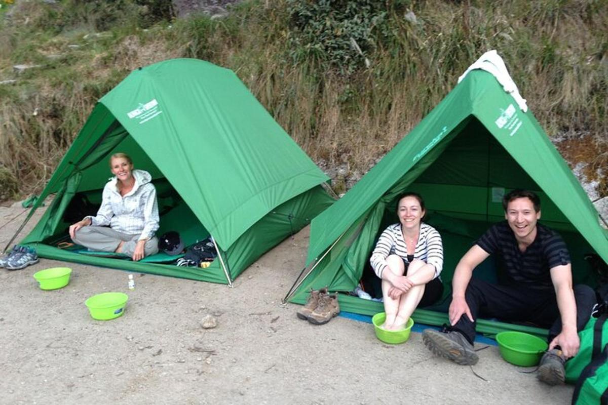 drie mensen zitten in een tent op het strand