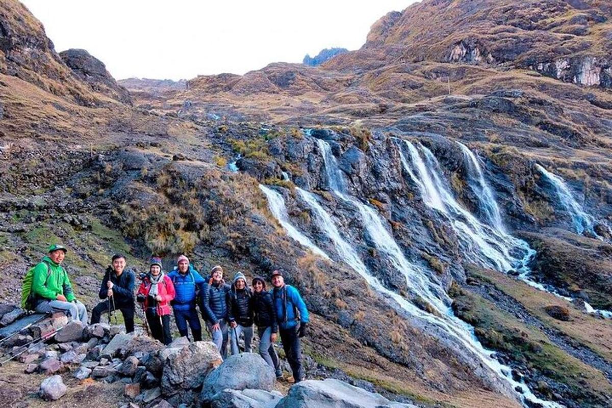 a group of people standing in front of a waterfall