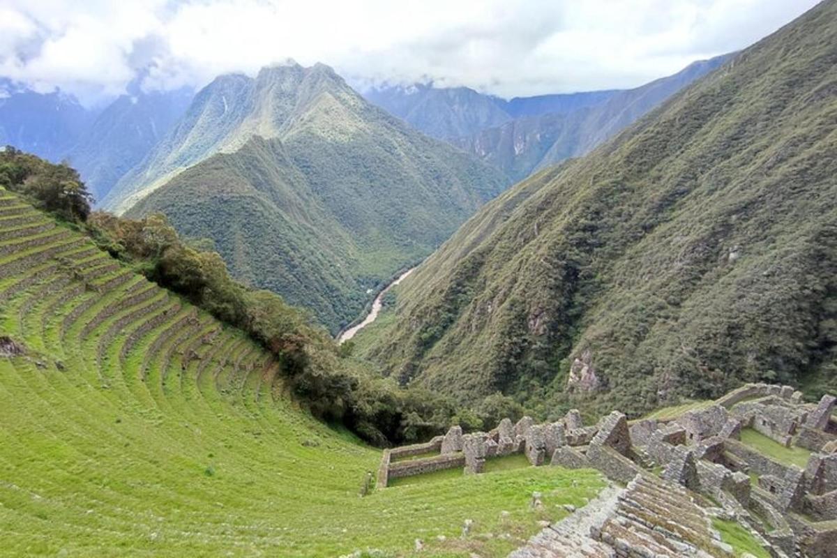 una vista di una valle di montagna con una rovina