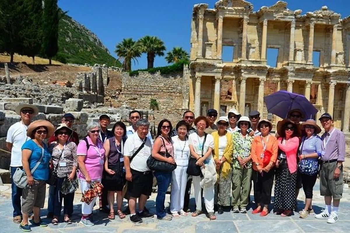 un grup de persones posant per a una foto davant de les ruïnes