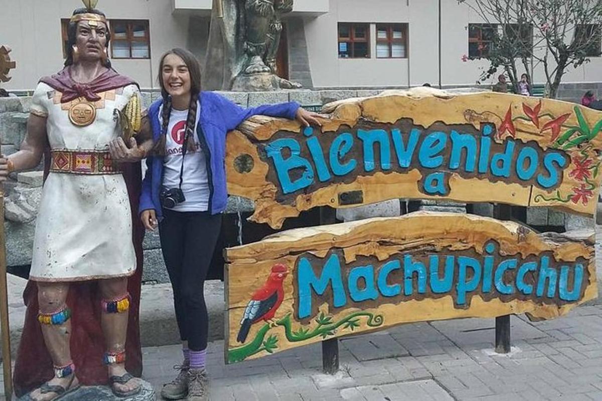 žena stojící vedle sochy vedle cedule