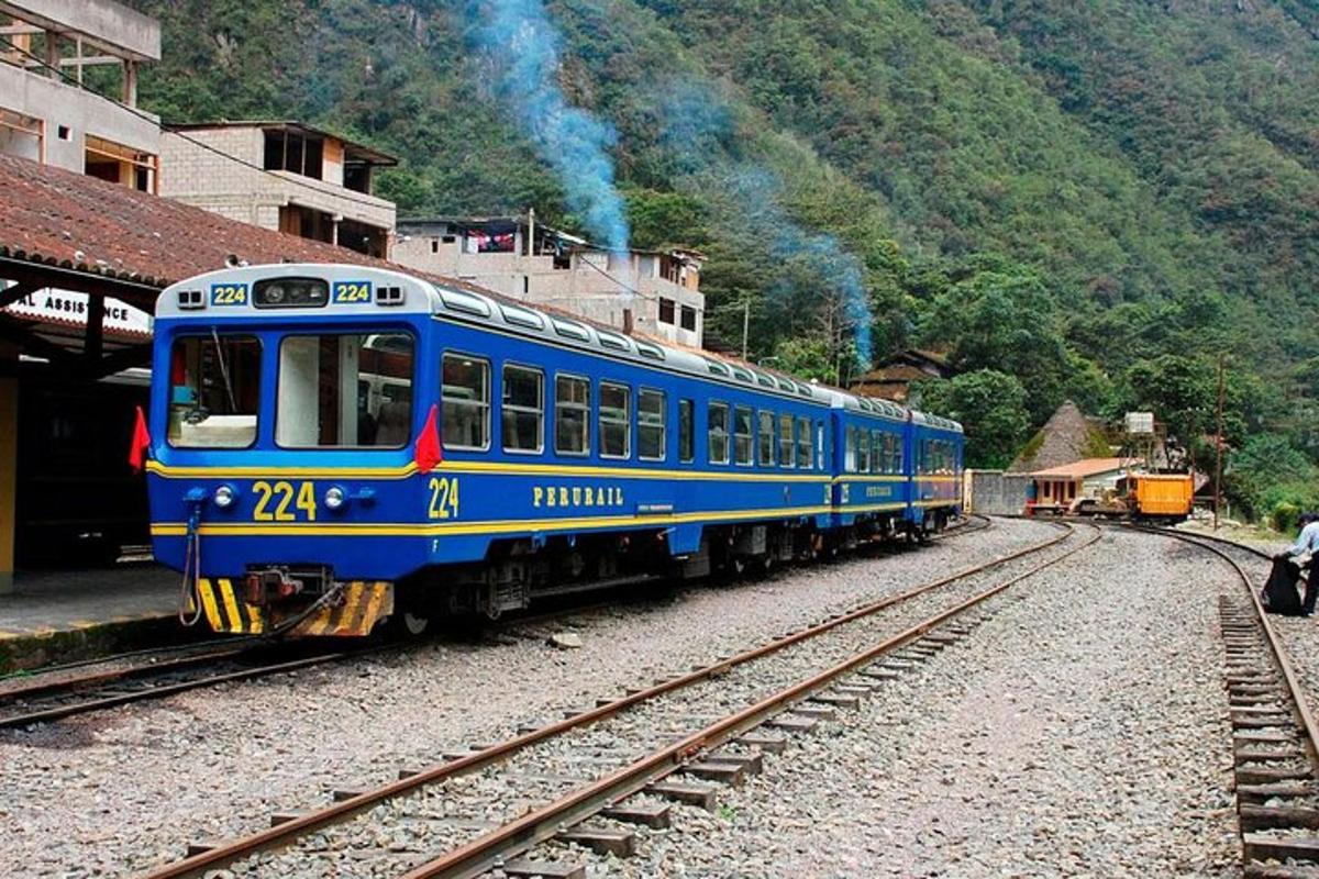 a blue train on the tracks at a train station