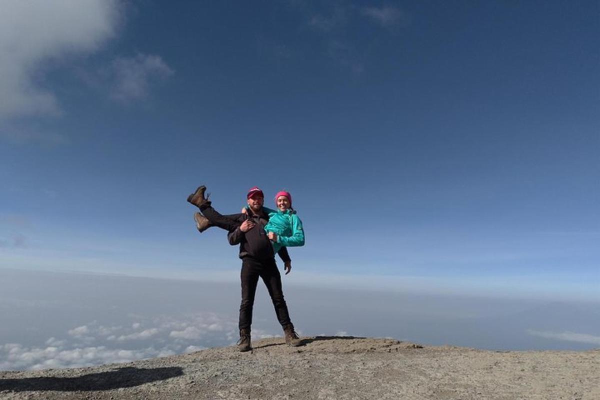 a man holding a child on top of a hill