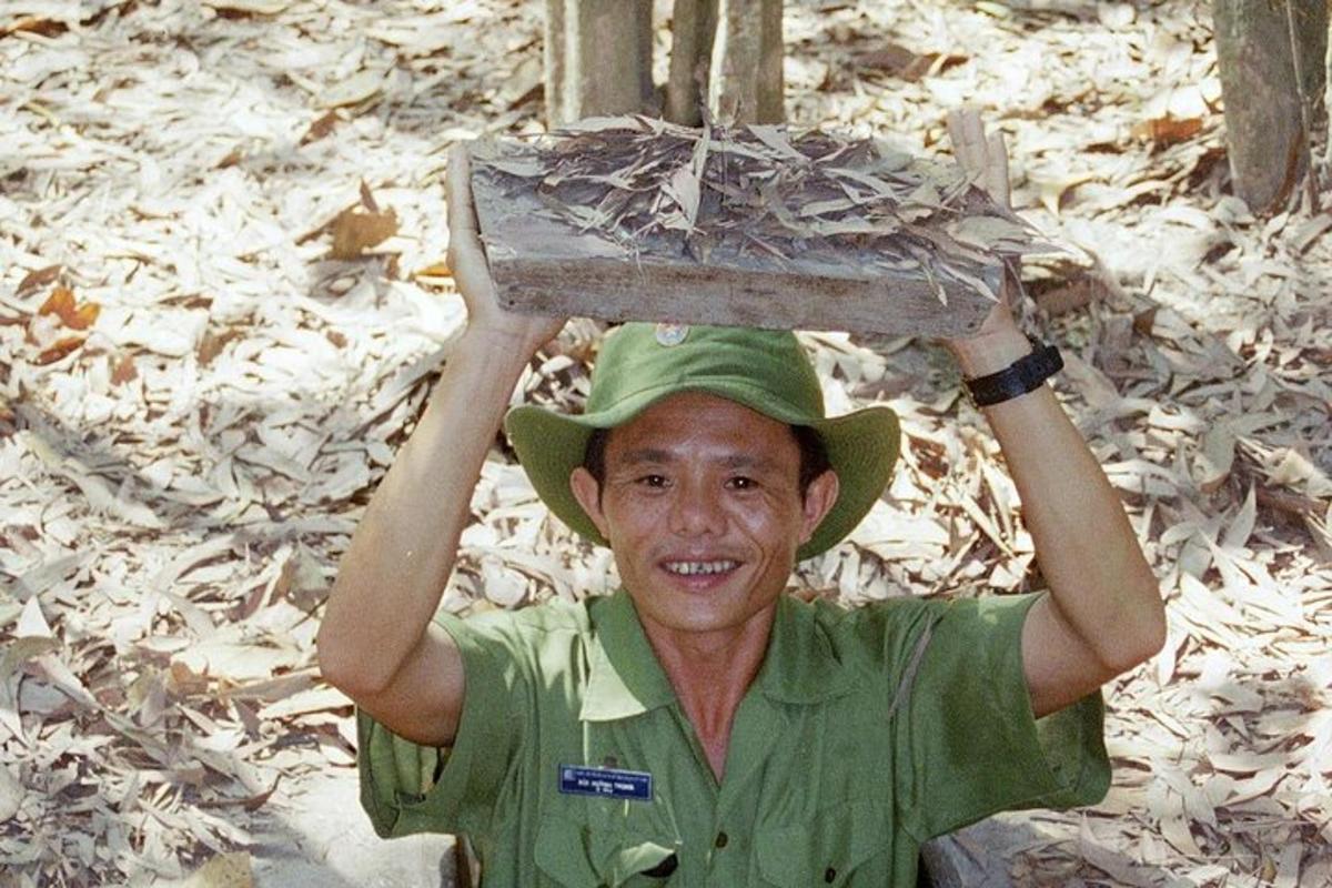 Un hombre con un uniforme verde que lleva una caja en la cabeza.