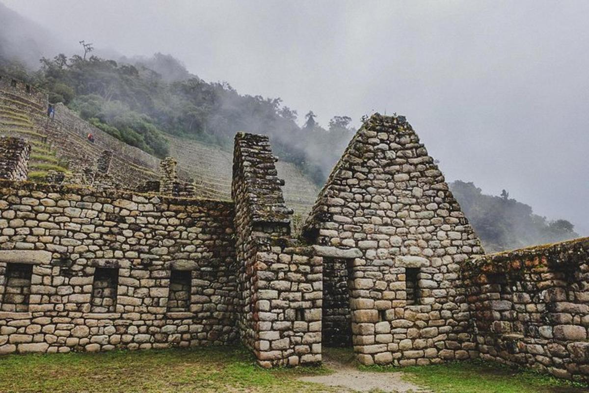 um grupo de edifícios de pedra com montanhas ao fundo