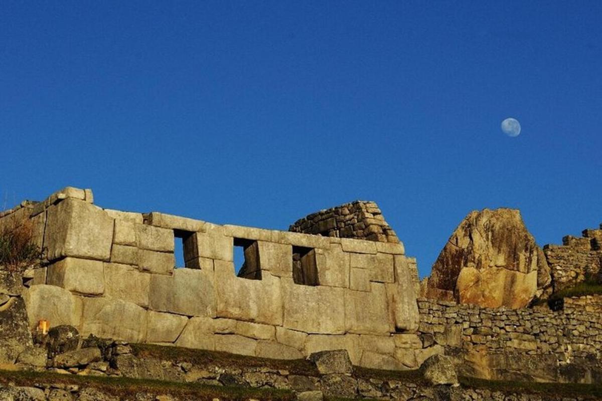 un vecchio edificio in pietra con la luna nel cielo