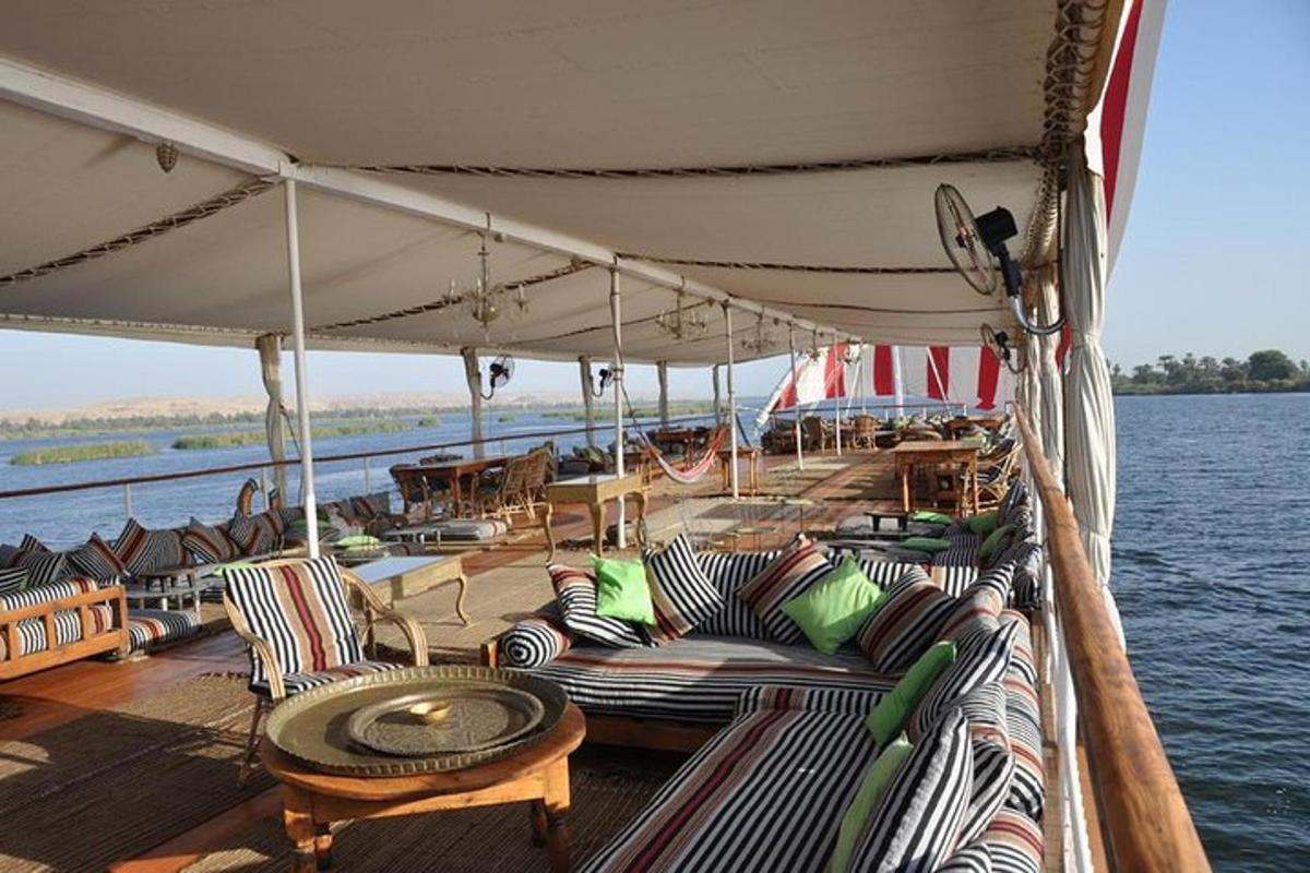 a boat with chairs and a table on the water