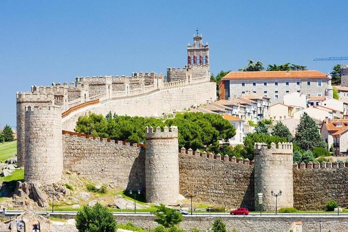 Un castillo con varias torres con una ciudad al fondo.