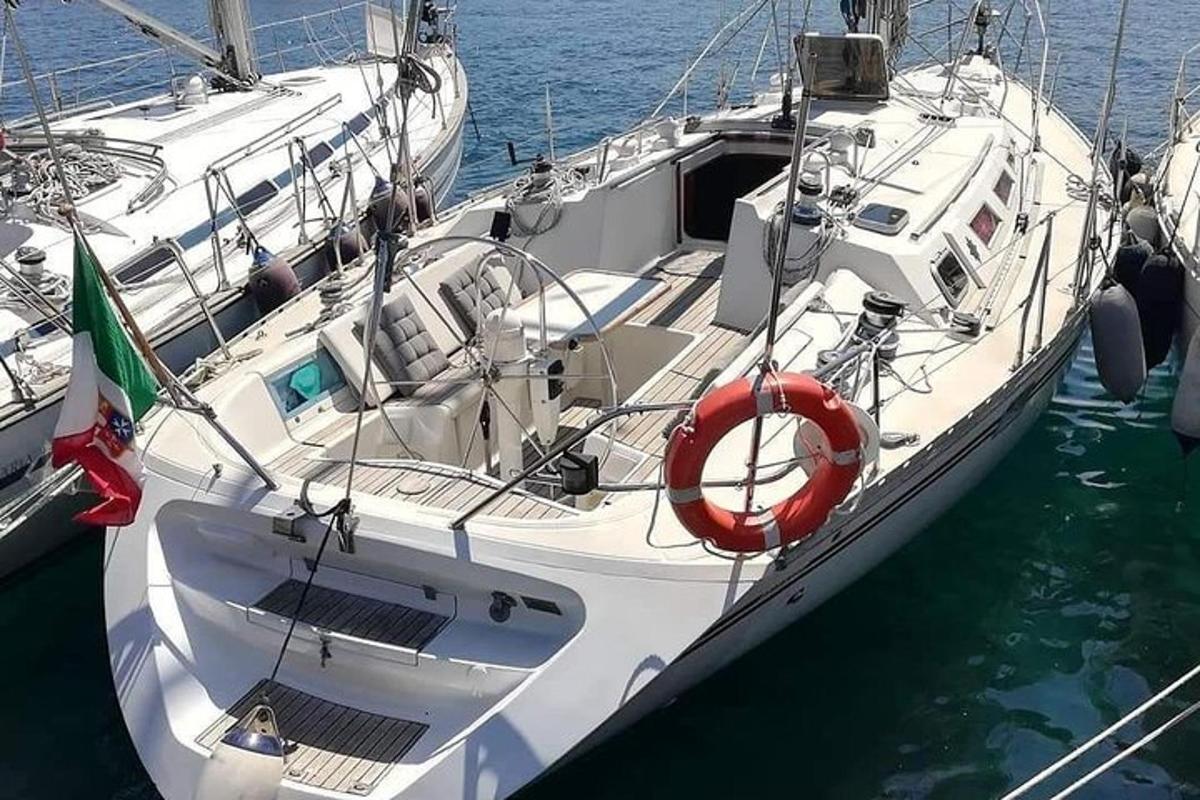 μια άσπρη βάρκα είναι αγκυροβολημένη στο νερό