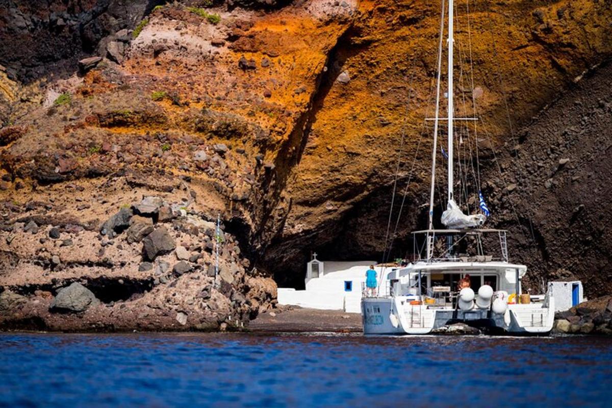 a boat sitting in the water next to a cliff