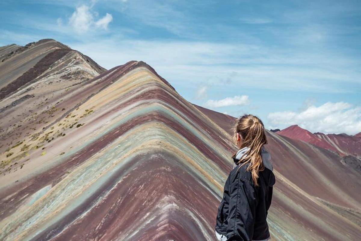 一位女士站在一座彩绘山峰旁