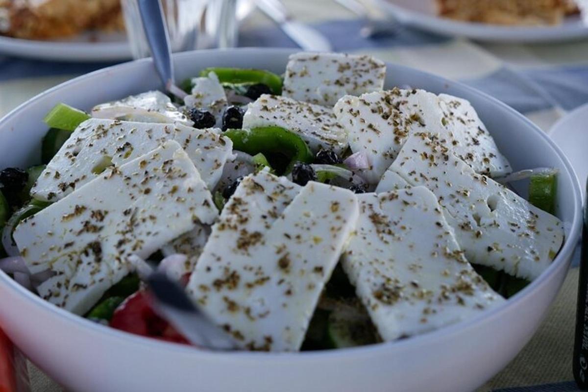 una ciotola di insalata con formaggio e verdure su un tavolo