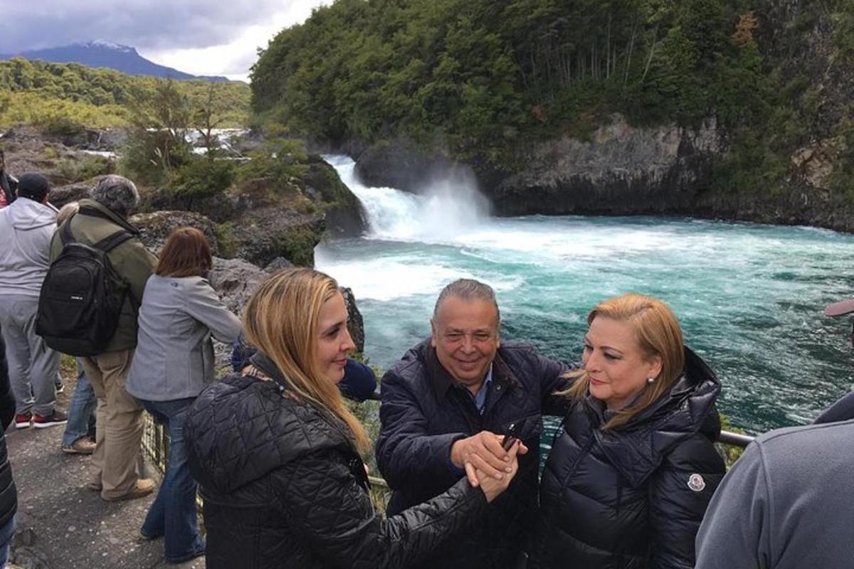 a group of people standing in front of a waterfall