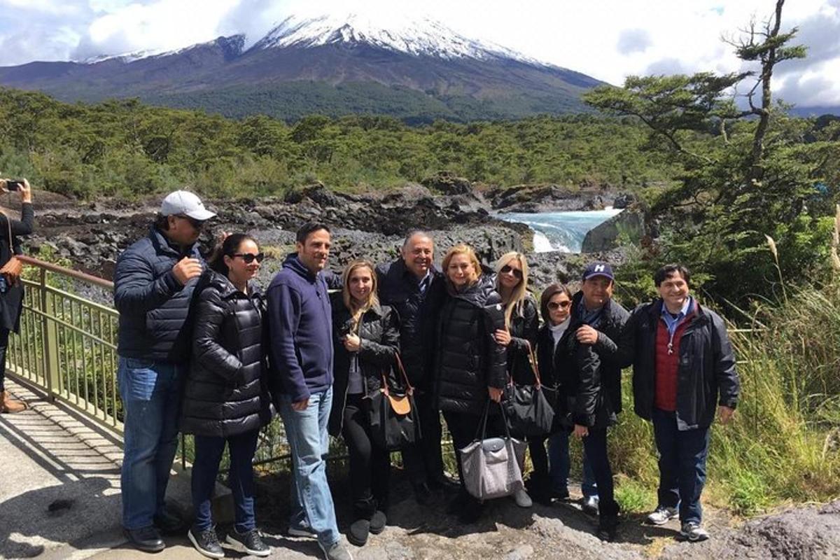 a group of people posing for a picture in front of a mountain