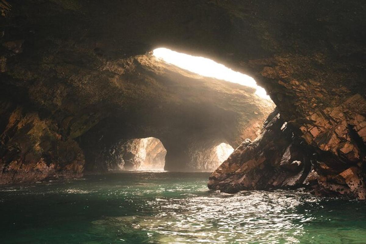 sebuah gua dengan sungai di hadapan tebing