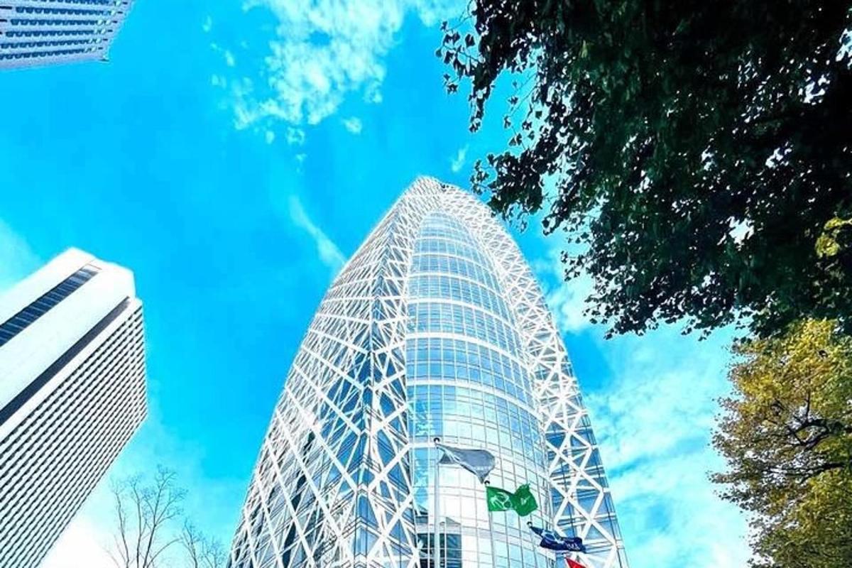 a tall glass building with a blue sky in the background