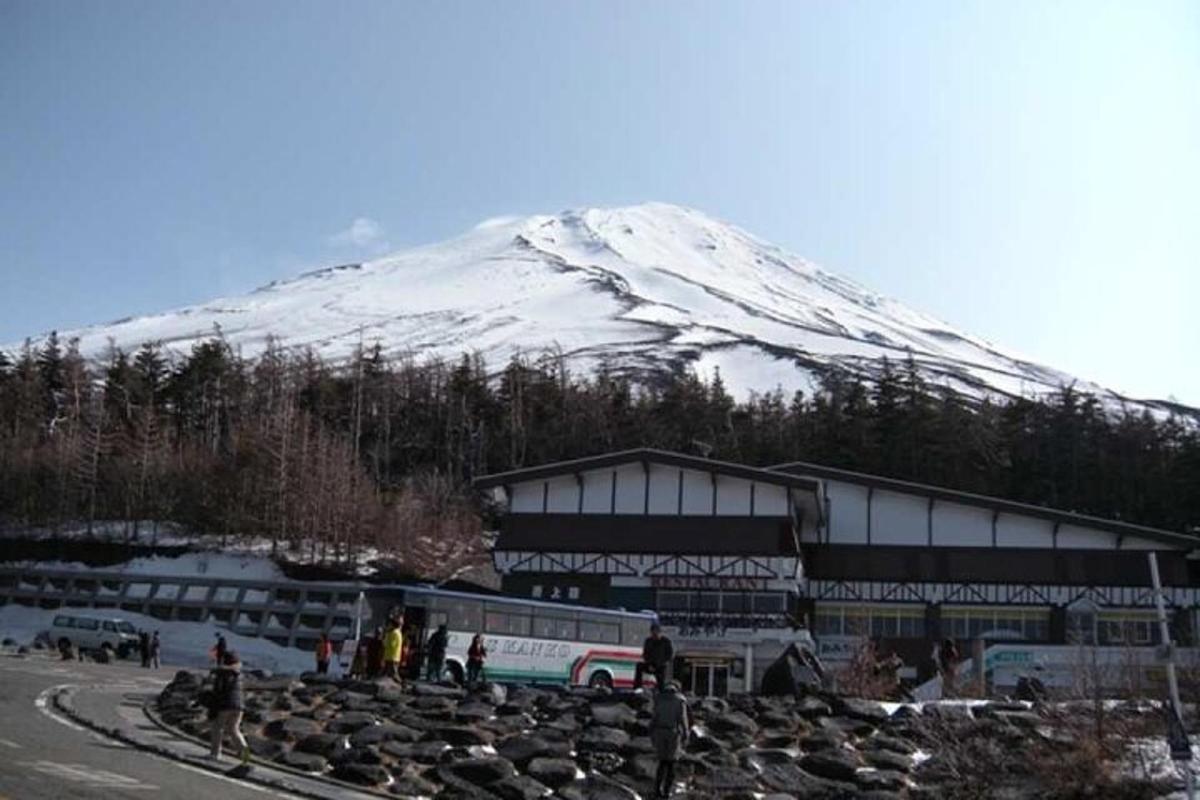a large building with a snow covered mountain in the background