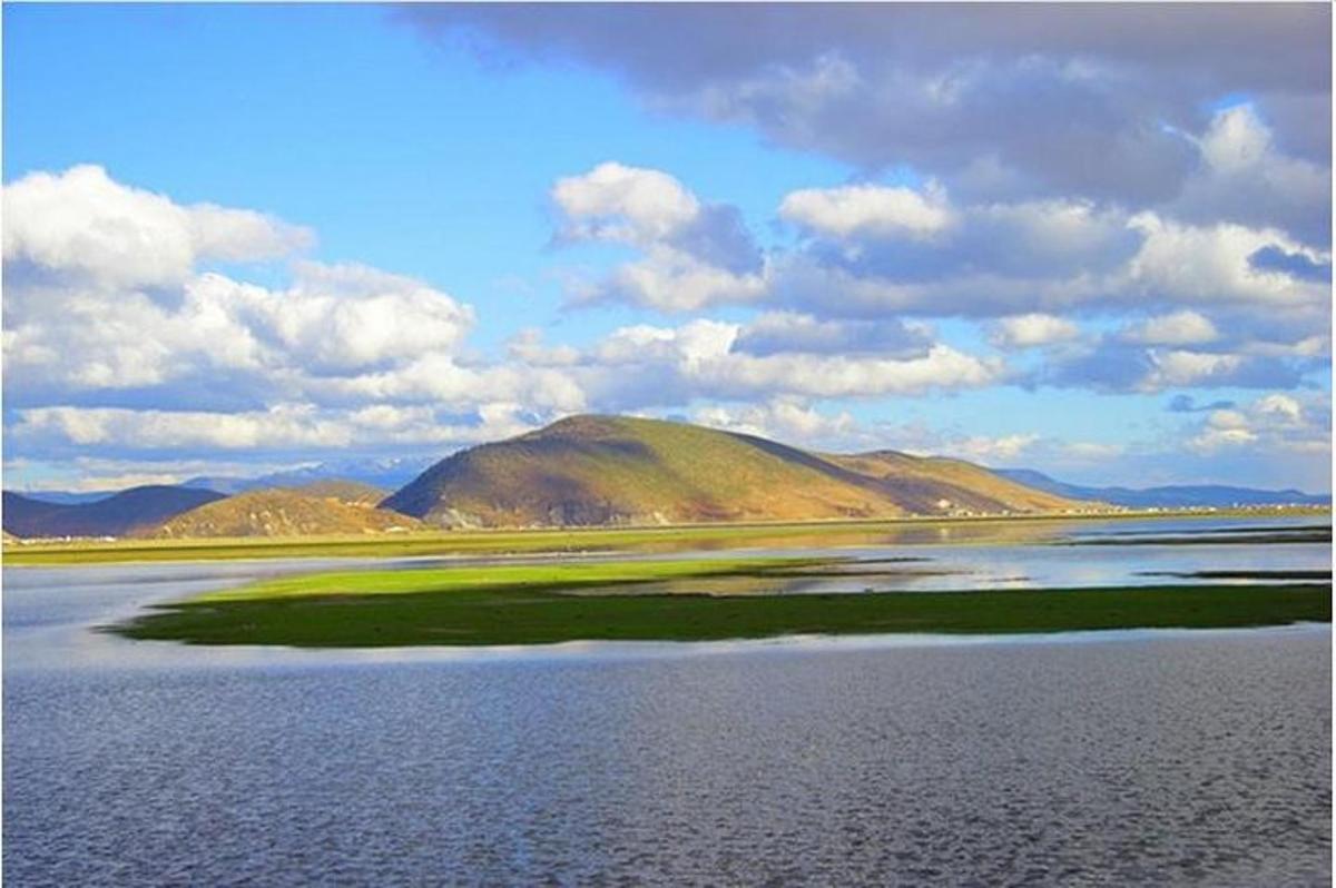 Un gran cuerpo de agua con una montaña al fondo