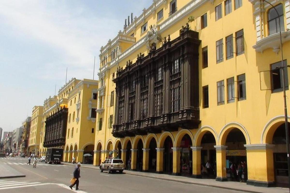 una persona che attraversa la strada davanti a un edificio giallo