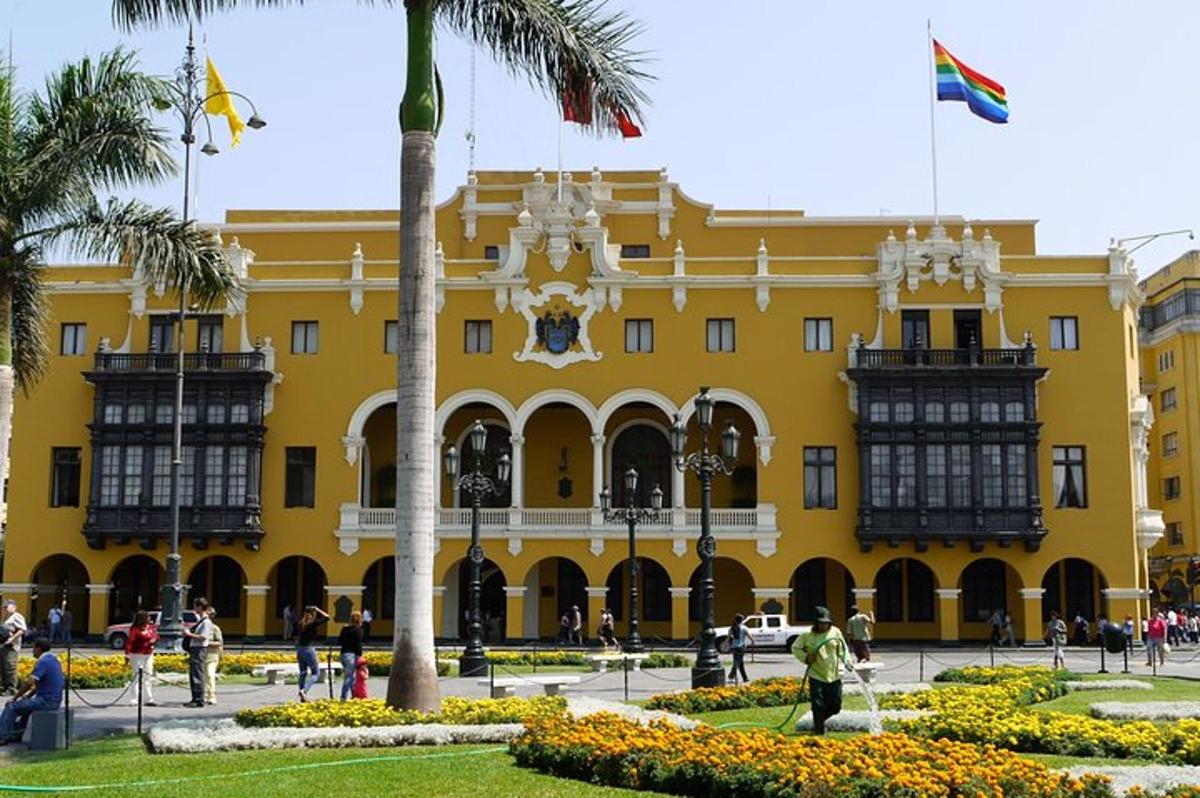 un edificio giallo con una palma di fronte