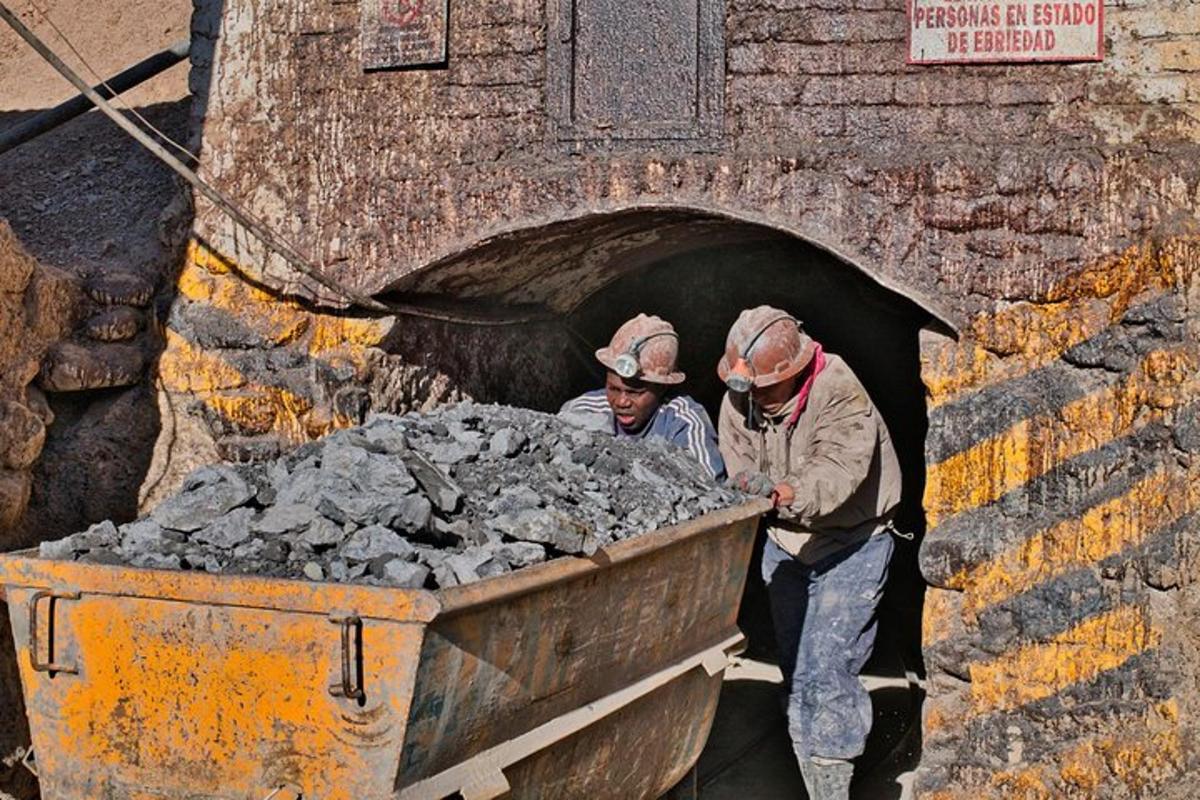two men are standing in a truck full of rubble