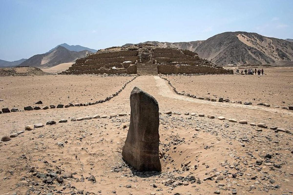 skála uprostřed pouště s pyramidou