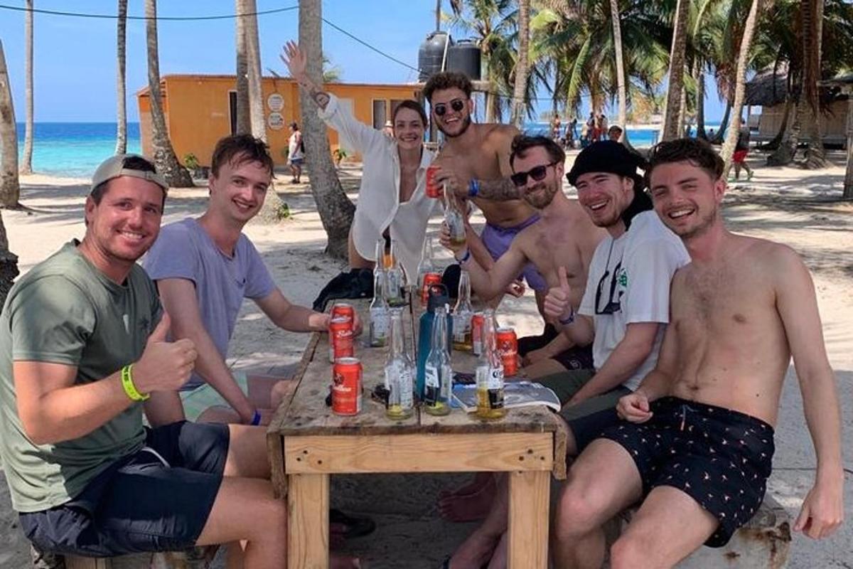 un gruppo di uomini seduti attorno a un tavolo sulla spiaggia