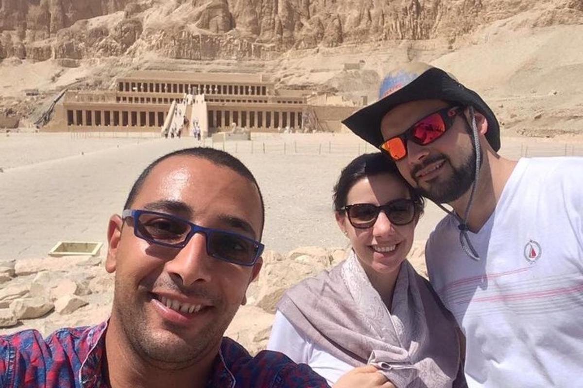 tre persone posano per una foto davanti a un edificio