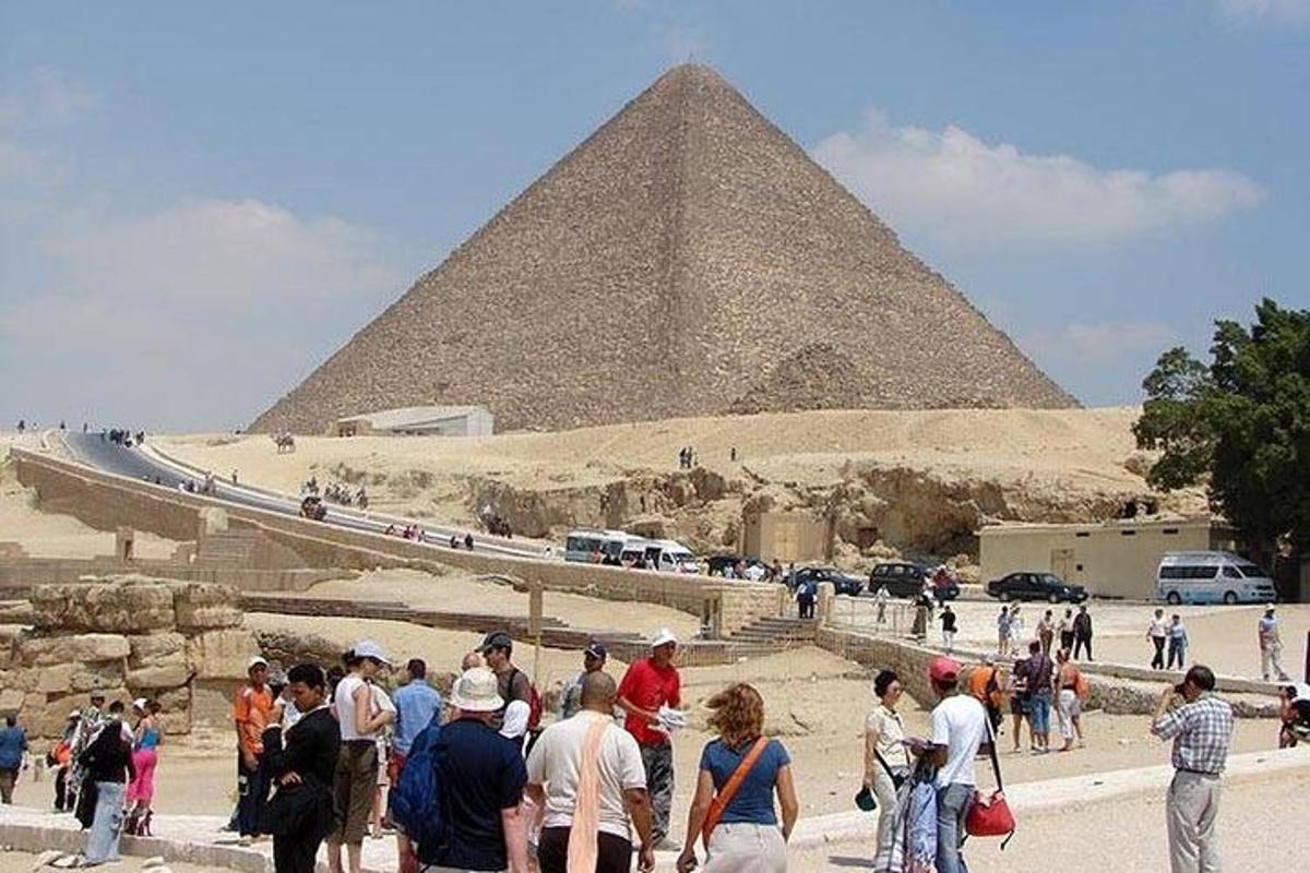 un groupe de personnes debout devant une pyramide