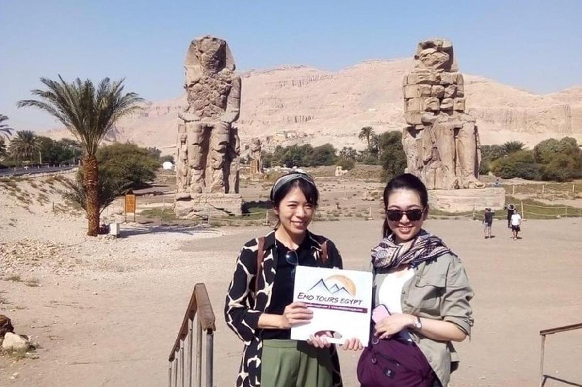 due donne che tengono un cartello davanti a una statua