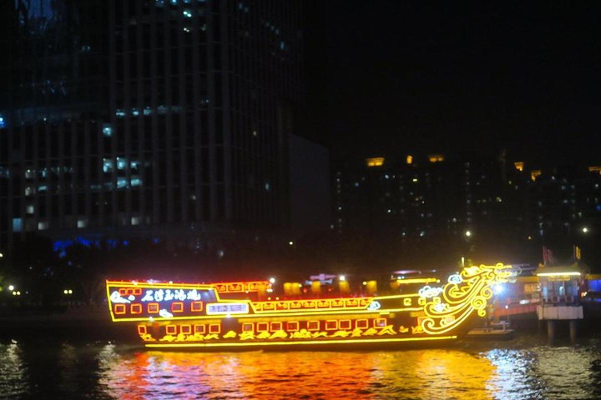 a boat covered in lights on the water at night