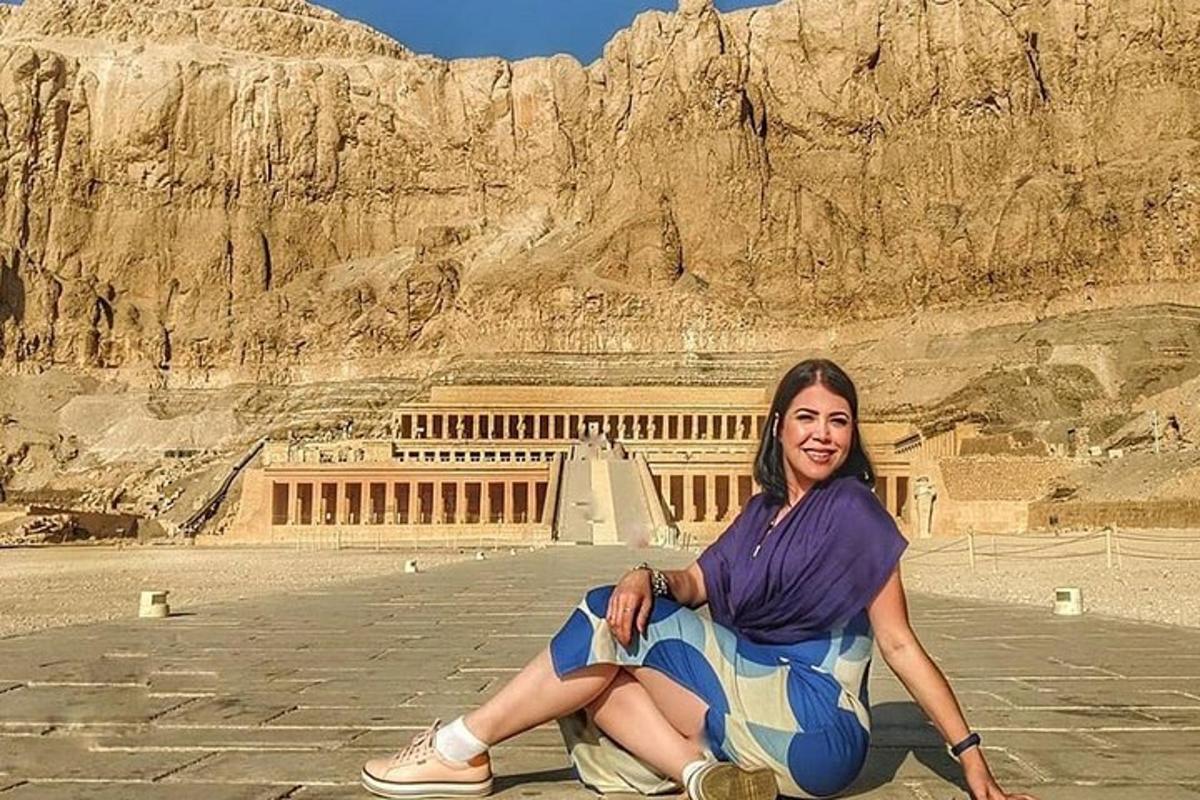 una donna seduta a terra davanti a un edificio
