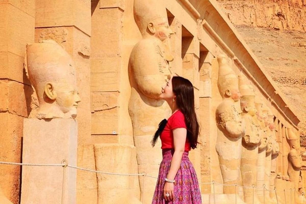 una donna in piedi davanti a un muro con statue